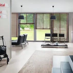 Modernes Krankenhaus-Wartezimmer mit Rollator, Sitzgelegenheiten und Blick in den Garten.