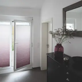 Helles Wohnzimmer mit modernen Plissees am Fenster und stilvoller Dekoration auf der Kommode.
