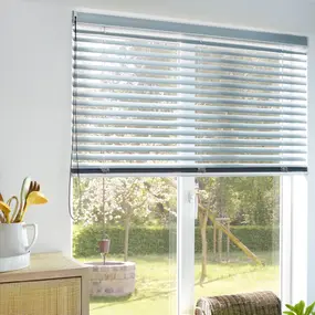 Helles Wohnzimmer mit modernem Plissee-Rollo am Fenster und Blick in grünen Garten.