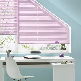 Arbeitszimmer mit weißem Schreibtisch, Stuhl und lila Plissee-Jalousie am Dachfenster.